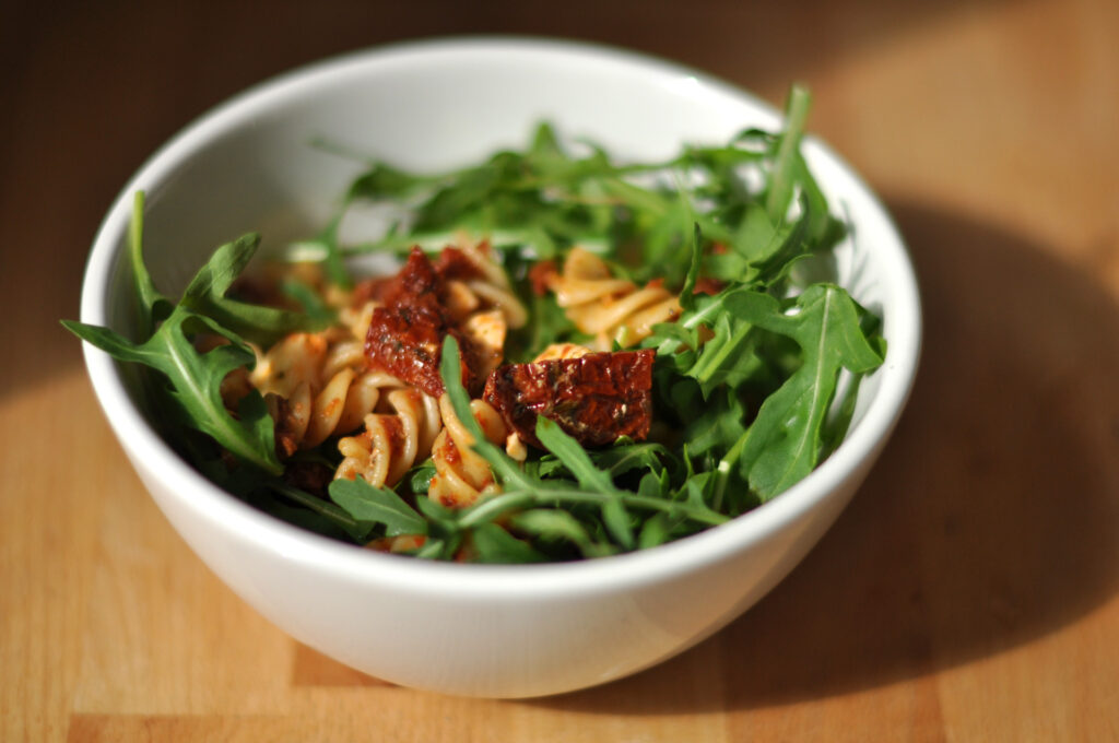 Nudelsalat mit getrockneten Tomaten, Mozzarella und Rucola