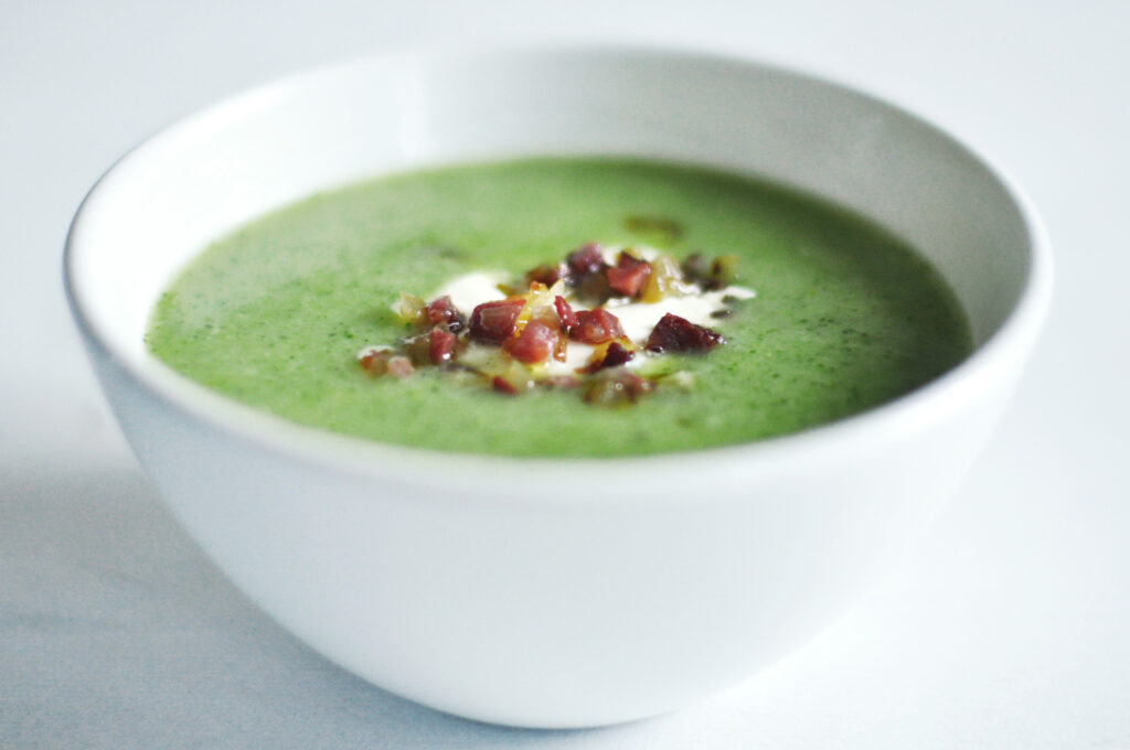 Brokkolisuppe mit Schinkenwürfeln und Zwiebeln