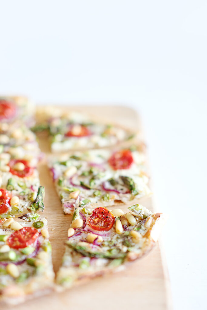Flammkuchen mit grünem Spargel, Tomaten und Pinienkernen
